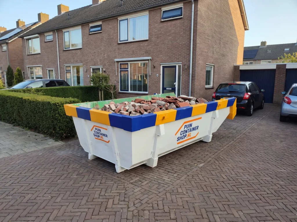 Container huren in Naaldwijk: afzetcontainer van Puincontainershop.nl op een oprit bij een woning