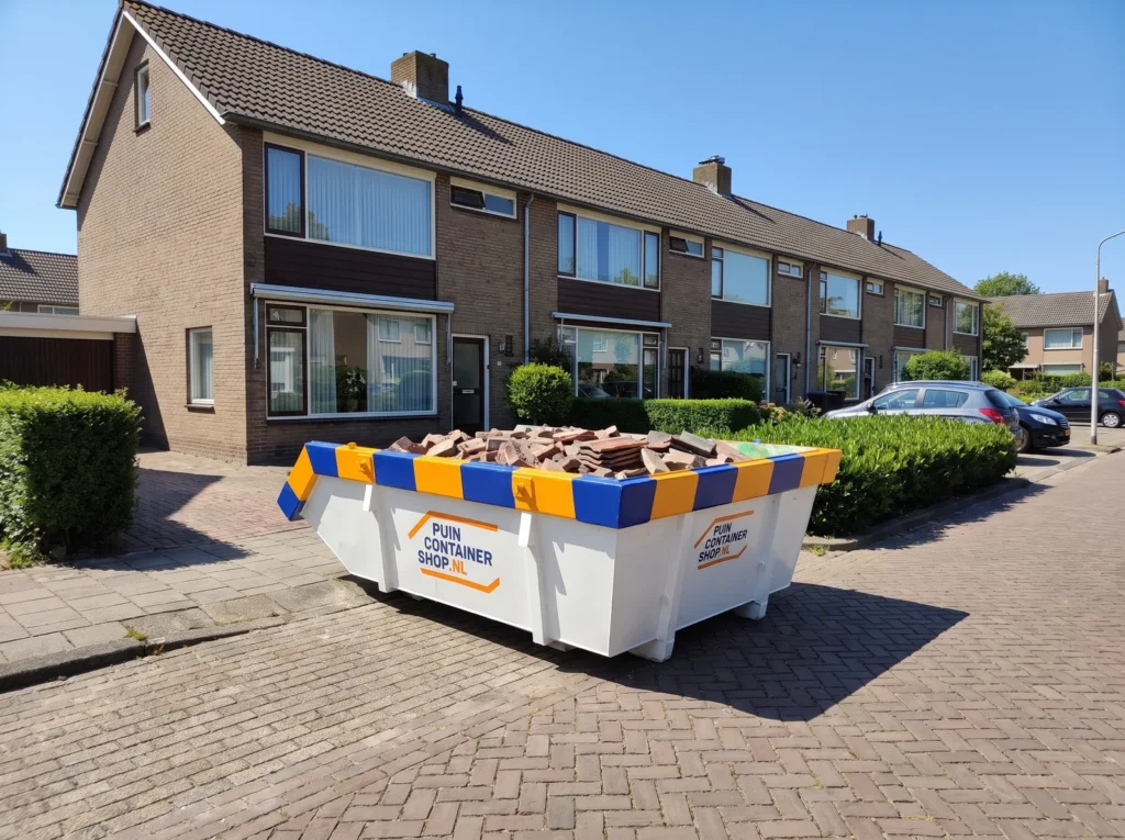 Container huren in Veendam: afzetcontainer van Puincontainershop.nl op een oprit bij een woning